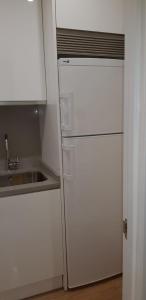 La cuisine est équipée d'un réfrigérateur blanc et d'un évier. dans l'établissement Piso 2da línea de playa en Marbella, à Marbella