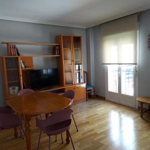 ein Wohnzimmer mit einem Tisch, Stühlen und einem TV in der Unterkunft RUA ZAPATERIA 10 PLASENCIA in Plasencia