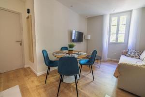 een woonkamer met een tafel en stoelen en een bank bij Le Palm Appartement élégant & Design En Bord Rivière in Collobrières