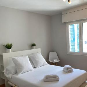 Un dormitorio con una cama blanca con toallas. en Mundaka best views house, en Mundaka