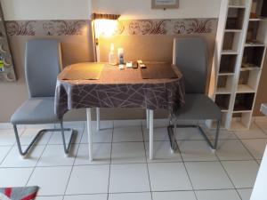 mesa de comedor con 2 sillas y mantel en Petite Callebasse, en Cayenne