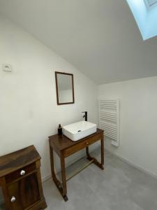 bagno con lavandino bianco e tavolo in legno di La vieille forge a Boussan