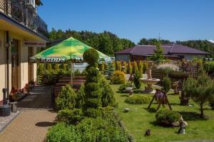 a garden with an umbrella and some bushes and trees at Willa Enigma in Dębki