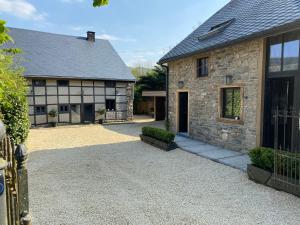 una casa in pietra con un vialetto di fronte di Paddock Lodge - Suites Wellness & Chambres d'hôtes a Stoumont