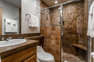 uma casa de banho com um chuveiro, um WC e um lavatório. em Snowmass Mountain by Snowmass Vacations em Snowmass Village