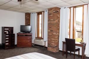 a room with a bed and a desk and a tv at Mountain View Lodge in Clifford
