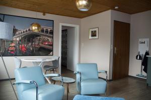 een wachtkamer met stoelen en een tafel en een schilderij bij Nikolaierhaus in Feldkirchen in Kärnten