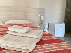 a bedroom with a bed with towels on it at NARANJA in Marina di Schiavonea
