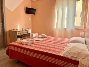 a bedroom with a bed and a desk with a television at NARANJA in Marina di Schiavonea