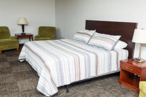 une chambre d'hôtel avec un lit et deux chaises dans l'établissement Mountain View Lodge, à Clifford