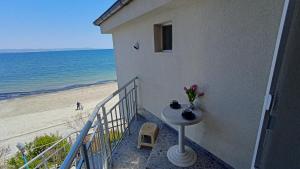 帕莫瑞的住宿－Nikolovi Home Apartments，阳台配有桌子,享有海滩美景