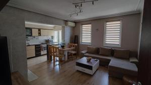 uma sala de estar com um sofá e uma mesa em Nikolovi Home Apartments em Pomorie