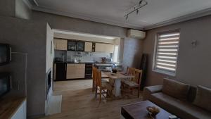 uma sala de estar e cozinha com uma mesa e um sofá em Nikolovi Home Apartments em Pomorie