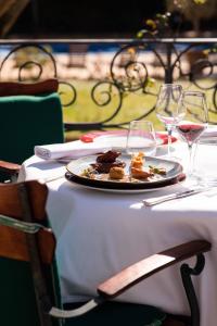a plate of food on a table with wine glasses at Domaine d'Auriac - Relais & Châteaux in Carcassonne