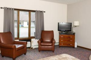 a hotel room with two chairs and a television at Mountain View Lodge in Clifford +8 photos