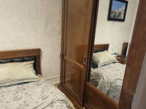 a bedroom with two beds and a mirror at Maison confortable vue sur mer in Zeralda