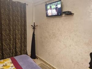 a bedroom with a tv on the wall and a bed at Maison confortable vue sur mer in Zeralda