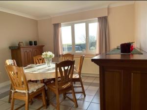 a dining room with a table and chairs and a window at Het Damhert in Kortenaken