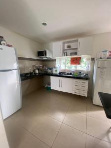 a kitchen with white appliances and a white refrigerator at Casa em Condomínio, Aquiraz - CE in Aquiraz +11 photos