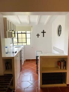 a kitchen with a counter and a cross on the wall at Hotel Spa Posada Tlaltenango in Cuernavaca