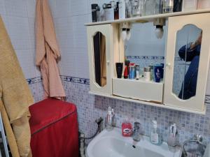 a bathroom with a sink and a red stool at Bel appartement proche de l'aéroport in Alger