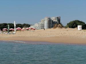 a beach with umbrellas and a building in the background at Алюр студио Приморско - Studio Allure Primorsko in Primorsko