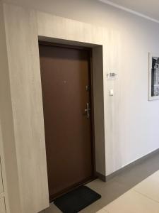 a brown door in a room with a wall at Apartament City Centre 108 in Olsztyn