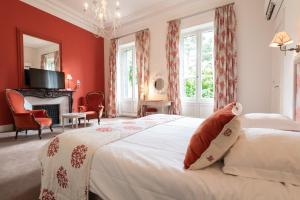a bedroom with a bed with red walls and a fireplace at Domaine d'Auriac - Relais & Châteaux in Carcassonne +78 photos
