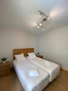 a bedroom with a large white bed with a ceiling at Mundaka Best Views House in Mundaka