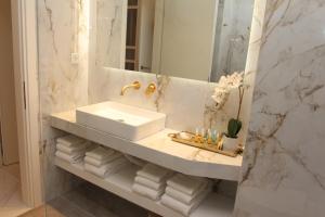 a bathroom with a sink and a mirror and towels at Adri & Marg luxury living in Athens