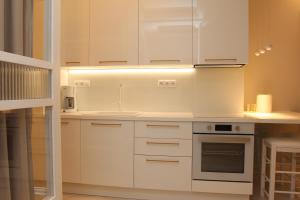 a kitchen with white cabinets and a stove top oven at Adri & Marg luxury living in Athens