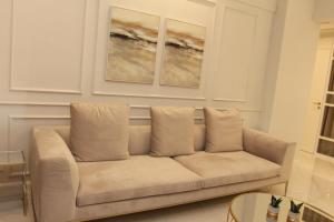 eine Couch in einem Wohnzimmer mit zwei Gemälden an der Wand in der Unterkunft Adri & Marg luxury living in Athen