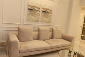 un sofá en una sala de estar con 2 pinturas en la pared en Adri & Marg luxury living, en Atenas 21 fotos más