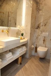 a bathroom with a sink and a toilet and a mirror at Adri & Marg luxury living in Athens