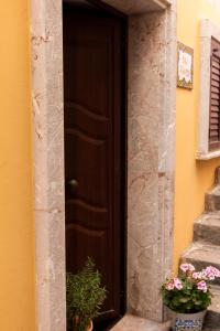a brown door with flowers on the doorstep at CASA FRANCY in Castelmola