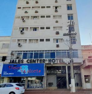 a tall white building with a sign on it at Jales Center Hotel in Jales