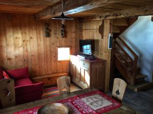 Ático de una cabaña de madera con mesa y sillas en Piccolo e accogliente rascard CIR 0060 en Champoluc