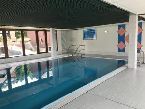 - une piscine avec des chaises dans un bâtiment dans l'établissement Ferienwohnung im Terrassenpark Sasbachwalden, à Brandmatt