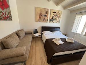 a small bedroom with a bed and a couch at Plaza Rooms in Avola