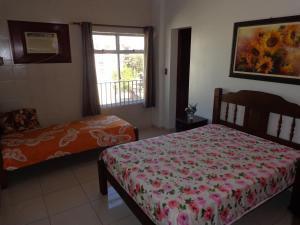 1 dormitorio con cama y ventana en Sinta-se em casa na praia do Forte, en Cabo Frío