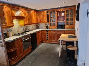 a kitchen with wooden cabinets and a table in it at The Old School House in Nether Poppleton