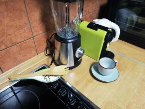 a blender on a counter with a cup and spoons at Guest house Gloria in Šilo