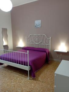 a bedroom with a bed with a purple blanket at Apartment Casa Francesca in Syracuse