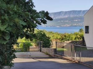 a gate to a house with a view of the water at Guest house Gloria in Šilo