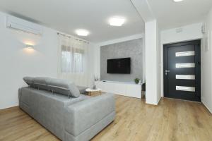 a living room with a couch and a flat screen tv at Apartment and room Mare in Zadar