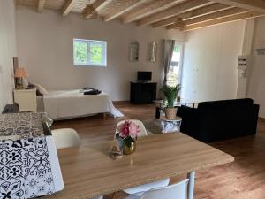 een woonkamer met een tafel en een bed bij Le Chêne: Petit Chalet cosy proche de Mulhouse in Riedisheim