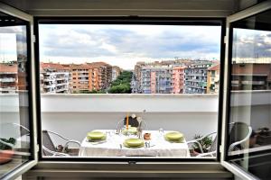 una mesa con platos amarillos en un balcón con vistas en Attico luminoso terrazza Metro A Aria Cond WiFi, en Roma