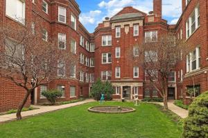 a courtyard of a large brick building with a fountain at City Charm Studio Apt close to Shops - Ashland 04 in Chicago