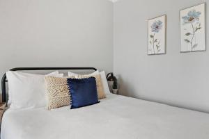 białe łóżko z poduszkami i dwa zdjęcia na ścianie w obiekcie City Charm Studio Apt close to Shops - Ashland 04 w Chicago