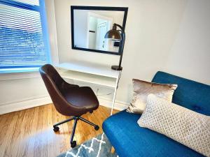 Una sala de estar con una silla y un sofá azul. en City Charm Studio Apt close to Shops - Ashland 04, en Chicago